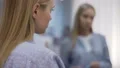 Young lady applying lipstick before date, altering appearance by make up 4k or 4k+ Resolution