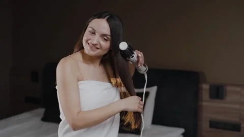 Young lady in bath towel drying hair at light room. Groomed woman hairstyling Video stock 241920050