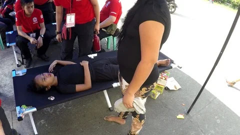Young lady brought to clinic after fainting in procession Stock Footage