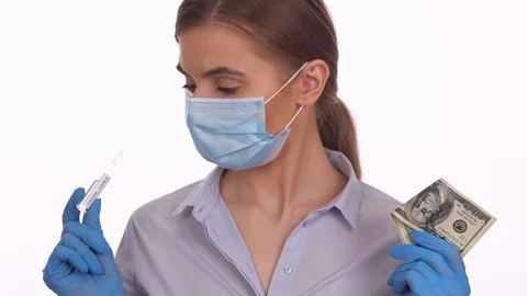 Young lady choosing between COVID-19 vaccine and dollar money Video stock 129060554