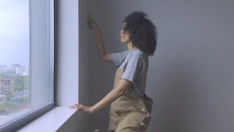 A Young Lady Is Creating a Mural While Positioned Near a Window. Stock Footage 313349637