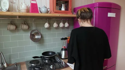 Young lady dancing, singing and cutting peach in the kitchen. Stock Footage 159339343