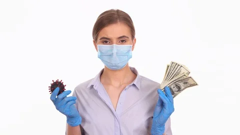 Young lady decide between COVID-19 virus cell and dollar money Video stock 129059551