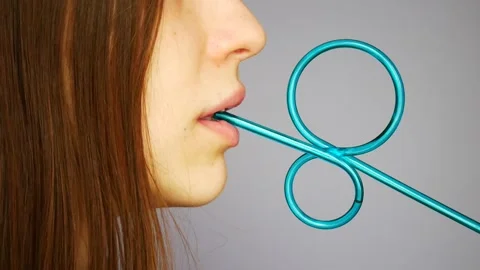 A young lady drinks from a beautiful blue straw Stock Footage 145177299