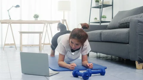 Young lady exercises doing working out planks with a leg outstretched at home. Stock Footage 133989457
