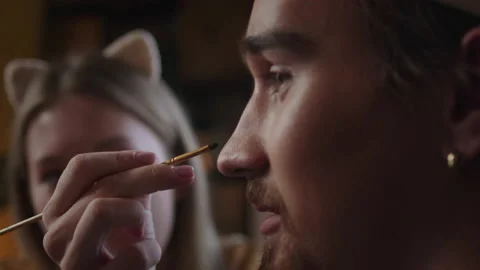 A young lady is explaining her friend how to draw greasepaint Video stock 170203365