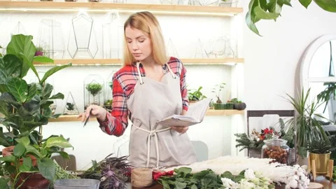 Young lady florist make notes at work Stock Footage 122739858