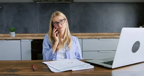 Young lady in glasses talks on mobile phone Stockbeeldmateriaal 256347057