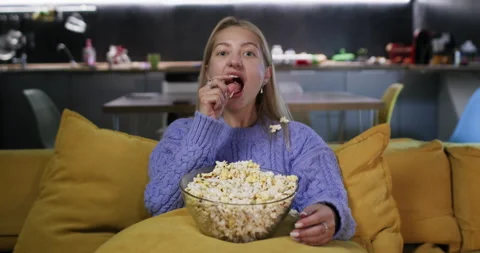 Young lady goofing around throwing popcorn into mouth Video stock 264477821