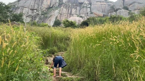 A young lady hiking mountain path to reach mountain top Vídeos de archivo 163754372