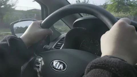 Young lady with jacket on drives a car with two hands on the steering wheel. Video stock 145682486