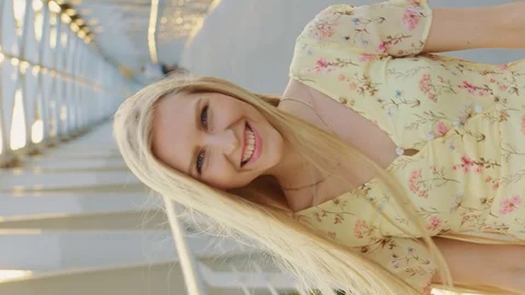 Young lady looking back on bridge. Pretty blonde woman looking back at camera Stock Footage 129881022