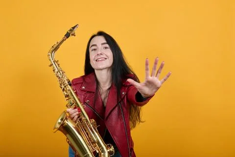 Young lady looking camera, keeping saxophone, smiling Stock Photos