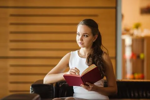 Young lady making notes in red diary. Woman in white dress planning Stock Photos