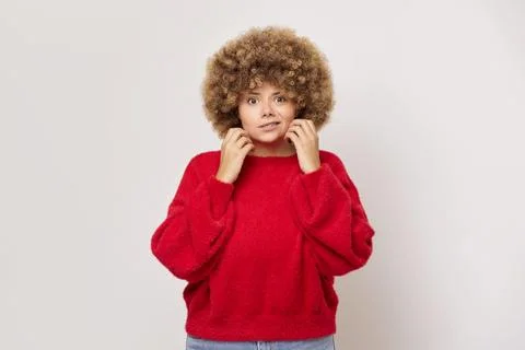 Young lady model makes wry mouth rising hands up to her face, pretty girl with Stock Photos