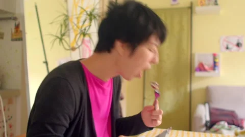 Young lady multitasking with notes and food in morning light Stock-Footage 324612758