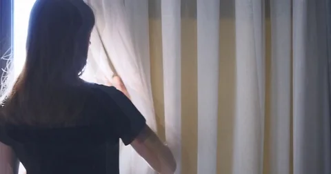 Young lady opens curtains of her hotel room. Stock Footage 73070096