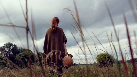 Young Lady In Poncho Standing In Grass With Clay Ewer In Hand Stock Footage 127540217