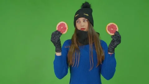 Young lady poses with two slices of grapefruit looking at them in turn. Stock Footage 157937776