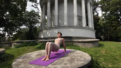 A young lady practices yoga outdoors Stock Footage 285336070