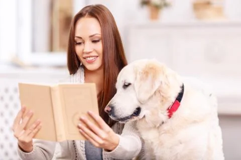 Young lady showing a book to her pet Stock Photos