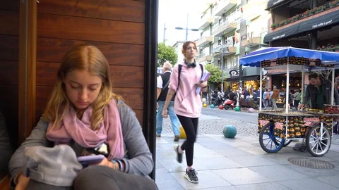 Young Lady Sitting At Cafe Table Texting With Phone Sitting At Table In City Vidéo 122104062