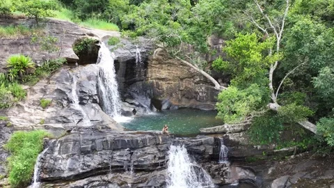 Young lady sitting in a natural pool of Diyaluma falls. Stock Footage 315337448