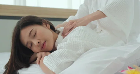 Young lady sleeping when she was doing massage on bed. Stock Footage 144983952