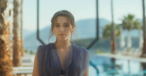 Young lady standing over the pool and looking at camera Stock Footage 112922206