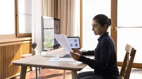 Young lady study data in report and on computer screens Foto stock
