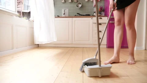 Young lady sweeps the floor in the kitchen. Stock Footage 159338888