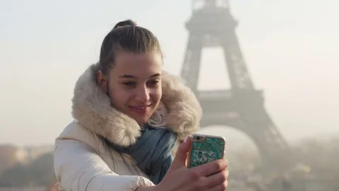 Young lady takes selfie in front of Eiffel tower in Paris Paris, France Stock Footage 74003143