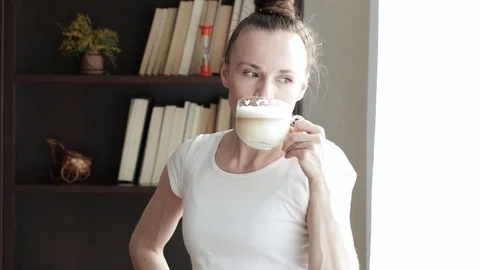 Young lady  is taking big cup of cappuccino in the morning. Stock Footage 75516165