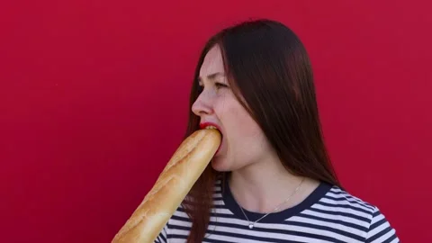 Young lady taking a bite of bread from a crispy baguette Stock Footage 137537511