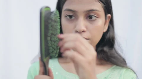 Young lady taking out lot of hair from the comb and get shocked. Stock Footage 311563355