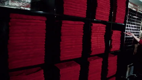 Young lady is taking red towel from stock in black shelves in luxury sport Stock Footage 88580387