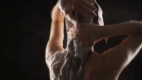 Young lady taking shower isolated over black background in slowmotion. Concept Stock Footage