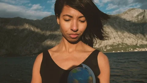 Young lady turns globe standing on ship outdoors. Video stock 76478867