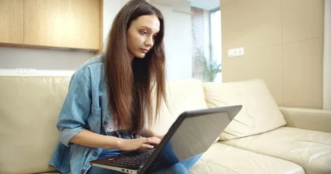 Young Lady Typing on Laptop in Empty Flat 動画素材 118178206