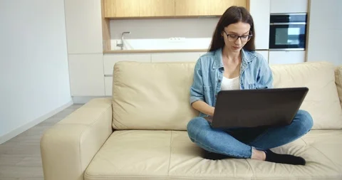 Young Lady Typing on Laptop in Empty Flat Stockbeeldmateriaal 118182262