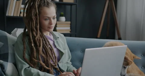 Young lady using laptop computer sitting on sofa with beautiful shiba inu dog Video stock 243811048