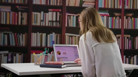 Young Lady Using a Laptop in the Library Stock Footage 85037814