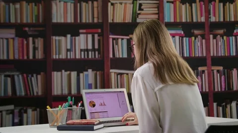 Young Lady Using a Laptop in the Library Stock Footage 85038209