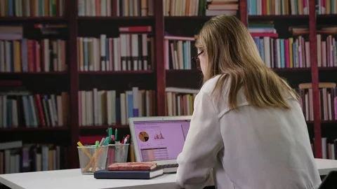 Young Lady Using a Laptop in the Library Stock Footage 85038763