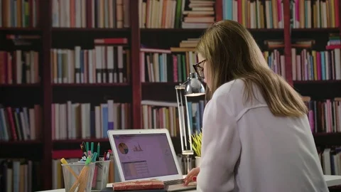 Young Lady Using a Laptop in the Library Stock Footage 85038917