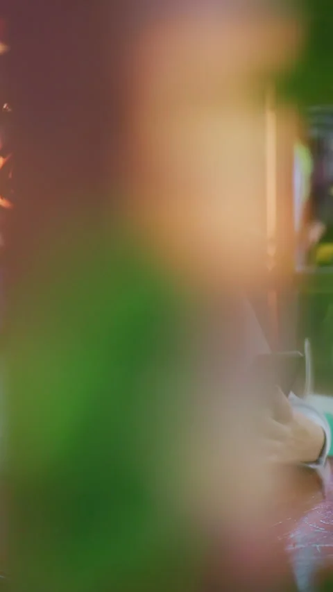 Young Lady Using Phone in Modern Cafe with Glowing Lights and Busy Background Stock-Footage 318839516
