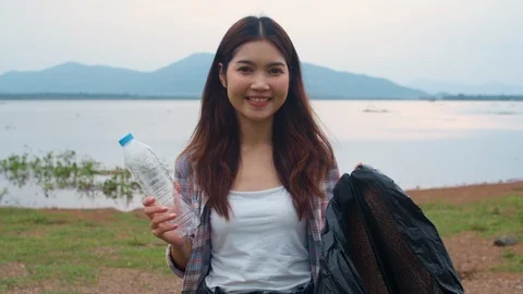 Young lady volunteers help to keep nature clean up holding plastic bottle. Stock Footage 122134831