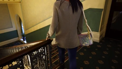 A young lady walking down the stairs at the Palace hotel in Buxton Stock Footage 104443828