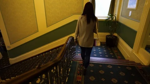 A young lady walking down the stairs at the Palace hotel in Buxton Stock Footage 104443928
