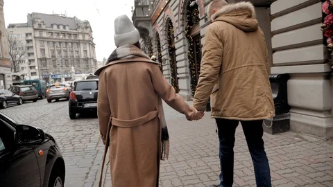 Young lady walking hand to hand with her husband on the street Stock Footage 129679944